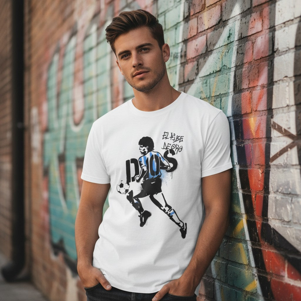 Globalfanz white 100% cotton t-shirt with a graffiti-style print of Maradona dribbling a soccer ball. Text reads 'El Pibe De Oro'.